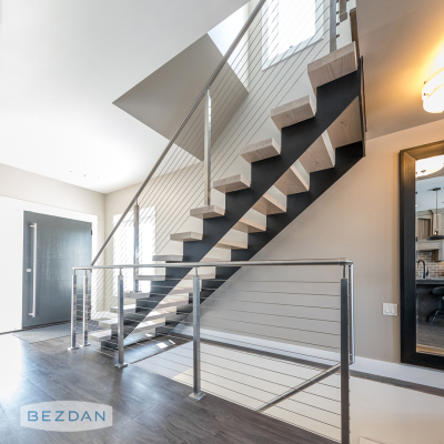 Interior stainless cable railing with square posts, 232 Series fittings, 9402 cover flange along a modern staircase.