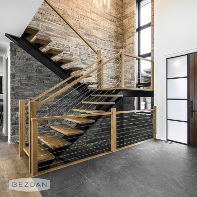 Interior cable railing with CR1630 surface mount tensioner, CR1635 non-tensioner, CR1600-500 cable along a modern staircase.