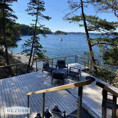 Coastal deck cable railing with through-post components for metal posts overlooking the ocean.