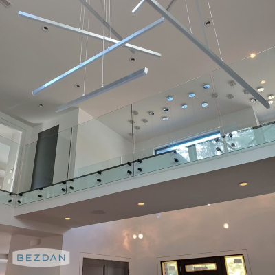 Glass railing with black stainless 1-1/2 standoffs 6102 installed along a loft balcony in a modern interior.